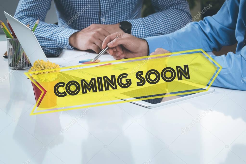 Coming Soon stylish lettering. Businesspeople on the background