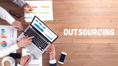 OUTSOURCING word concept on desk background