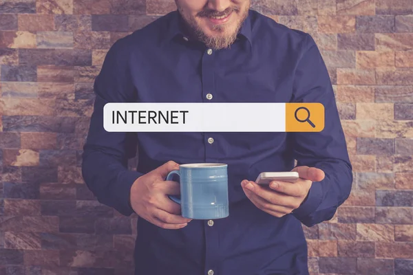 Hombre sosteniendo taza y teléfono inteligente — Foto de Stock