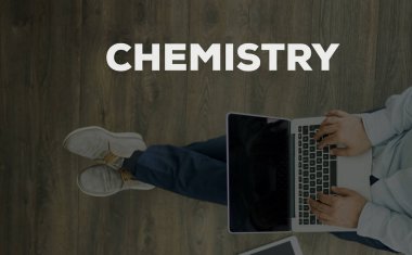 Genç adam dizüstü bilgisayarla yerde oturuyor.