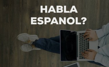 Genç adam dizüstü bilgisayarla yerde oturuyor.