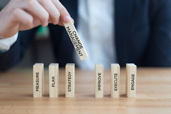 businessman playing with wooden blocks 