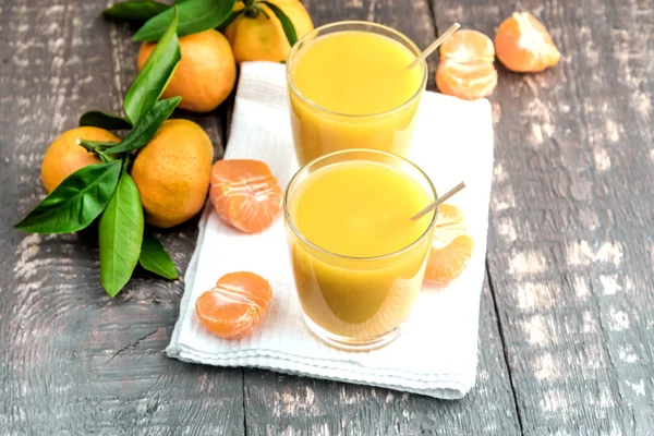 Olgun mandalina küçük bir bardak taze meyve suyu