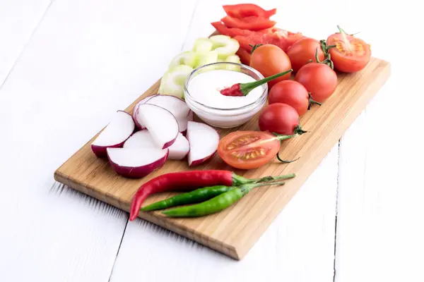 Chopped vegetables served on wooden kitchen board — Stock Photo, Image