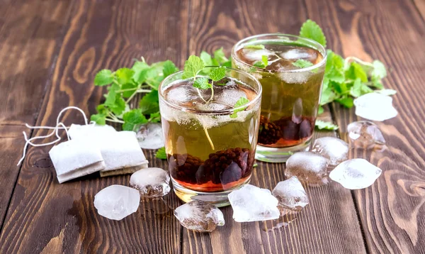 Chá de gelo com baga e hortelã fresca em óculos Fundo de madeira — Fotografia de Stock