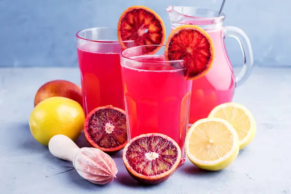 Glasses with blood orange and lemon lemonade Place for text Blue background — Stock Photo, Image