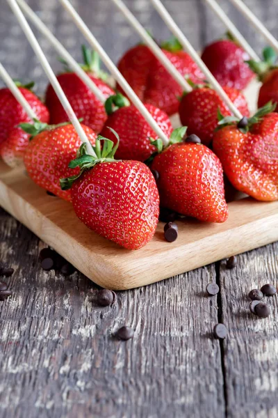 Frische Erdbeeren rote Erdbeeren schöne Erdbeeren am Spieß Erdbeeren auf Holzbrett vertikal Foto — Stockfoto