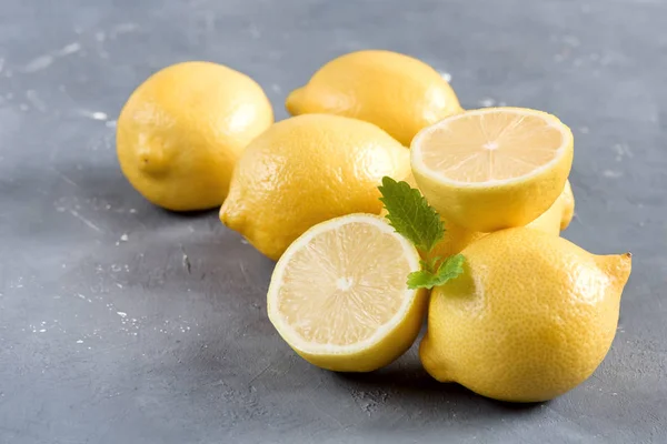 Лимоны на сером фоне Свежий желтый цитрусовый лист мяты — стоковое фото