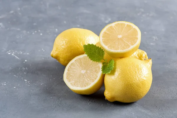 Лимоны на сером фоне Свежий желтый цитрусовый лист мяты — стоковое фото