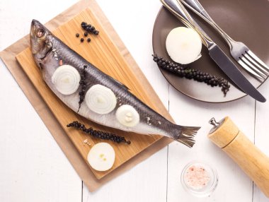 Soğan ve ahşap masa üzerine biber ile lezzetli tuzlanmış ringa Beyaz ahşap arka plan rustik tarzı Üstten Görünüm