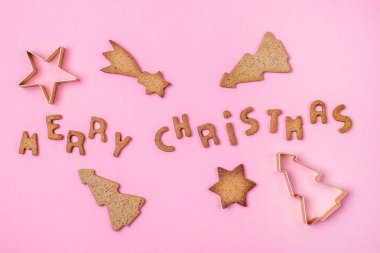 Noel Ev Yapımı Zencefilli ve Bal Kurabiyesi Kalıbı ve Harflerin Şeklinde Zencefilli ve Yıldızlı Pembe Arka planda Mutlu Noeller