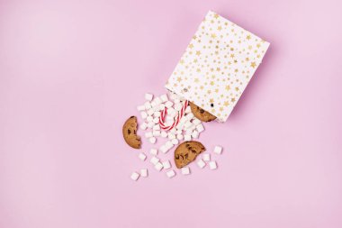 Beyaz Hediye Paketleri Marshmellow ve Tatlı Kurabiyeler ve Şeker Çubuğu Pembe Arkaplan Alışverişi ya da Gıda Tatili Kopya Mekanı