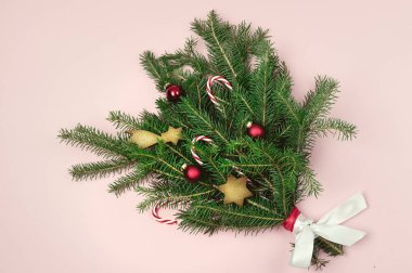 Yeşil Ağaç Ağacı Noel süsleri ile süslenmiş Kırmızı Toplar ve Pembe Kağıt Arkaplanda Zencefilli Kurabiyeler Üst Tarafta Yatay Noel Buketi