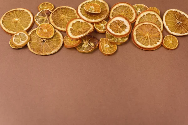 Torkade apelsinskivor Chips Dehydratiserad krispig Citrus Group of Sun Torkade knapriga apelsiner Friska mellanmål Ovanifrån Flat Lay Brown Bakgrund Kopiera utrymme — Stockfoto