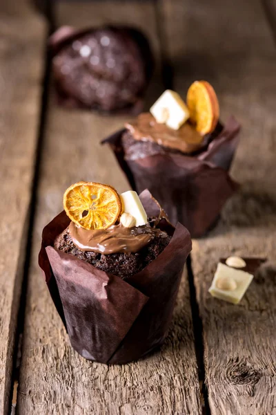 Három Ízletes Házi Csokoládé Muffin Papíron díszített fehér csokoládé és szárított Citrus függőleges fa háttér Ünnepi desszert — Stock Fotó