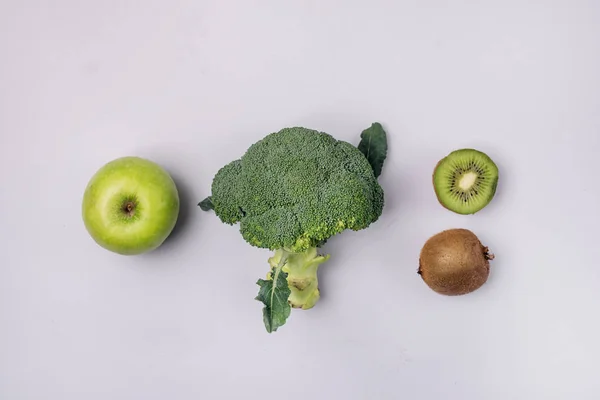 Gröna färgade frukter och grönsaker på den blå bakgrunden Gröna Apple Broccoli Kiwi Top View Flat Lay Diet Detox Food Concept Ingredienser för grön smoothie — Stockfoto