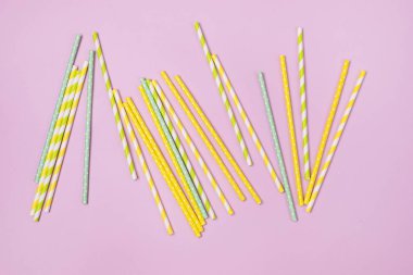 Pembe Arkaplan Üst Görünümü üzerinde farklı renklerde şeritli içecek pipetleri, yatay görünüm