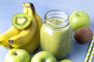 Sağlıklı Detox Yeşil Smoothie 'nin Gass Kavanozu Mavi Arkaplan Diyet Gıda Meyveleri Smoothie Çiğ Elmalar Kivi Saman Yatay