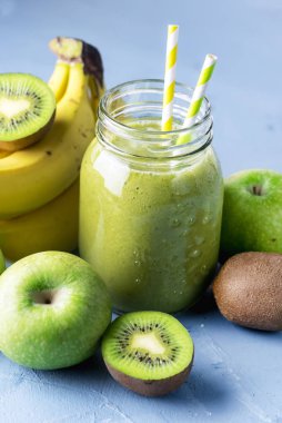 Sağlıklı Detox Yeşil Smoothie 'nin Gass Kavanozu Mavi Arkaplan Diyet Gıda Meyveleri Smoothie Çiğ Elmalar Kivi Saman Yatay