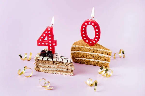 Two Tasty Piece of Cakes with Red Candles in the Form of Numbers Four and Zero on Pink Background Fortieth Birthday or Anniversary Celebration Birthday Cake