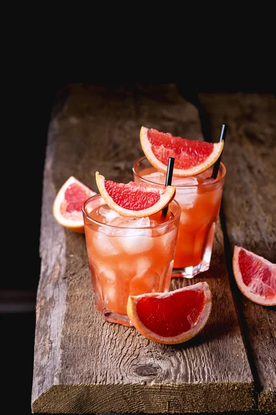 Dos vasos de pomelo sabroso bebida fría o cóctel sobre fondo de madera refresco bebida zumo de pomelo frío vertical — Foto de Stock