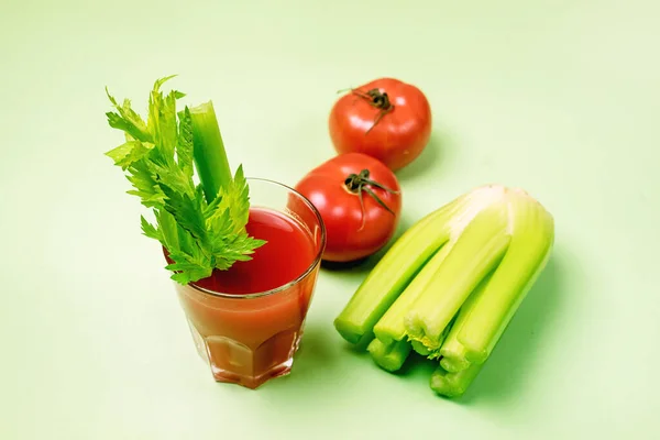 Glas leckere und gesunde Tomaten und Selleriesaft rohe Tomaten und Sellerie auf grünem Hintergrund horizontal — Stockfoto