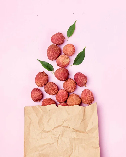 Sabroso Lychee orgánico en paquete sobre fondo rosa Vista superior vertical de la fruta asiática —  Fotos de Stock
