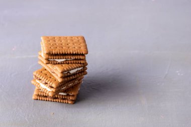 Gri arkaplanda lezzetli çikolatalı kurabiye yığını. Kahve için lezzetli tatlı. Yatay kopyalama alanı.