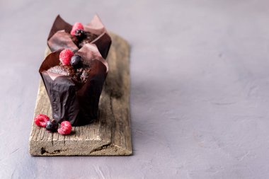 Çay ya da Kahve Kopyalama Uzayı için Eski Ahşap Tepsi Gri Arkaplan Tatlısıyla süslenmiş İki Lezzetli Çikolatalı Kek