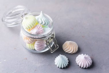 Gri arka planda cam kavanozlarda küçük kremalar Tatil için lezzetli tatlı hediyeler