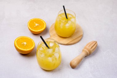 Lezzetli ve ferahlatıcı Portakal Suyu Bardakta Siyah kamışlarla Açık Gri Arkaplanda Taze Olmuş Portakallar Yatay Tahta Sıkarak