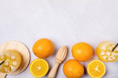 Açık Gri Arka plan Taze Portakal Kopyalama Alanında Siyah Pipetle Lezzetli ve Ferahlatıcı Portakal Suyu Bardakta