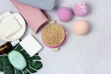 SPA Pembe Hayat Pembesi ve Açık Turuncu Banyo Bombaları Açık Gri Arkaplandaki Kozmetik Yağlar Yıkama Fırçası Gri ve Pembe Havlu Güzellik Konsepti