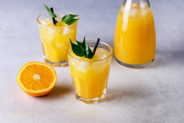 Açık Gri Arkaplanda Siyah Pipetle Lezzetli ve Ferahlatıcı Portakal Suyu Taze Olmuş Portakallar