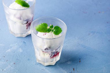 Gözlüklü ev yapımı vanilyalı dondurma ve nane şekeri mavi arka plan yatay