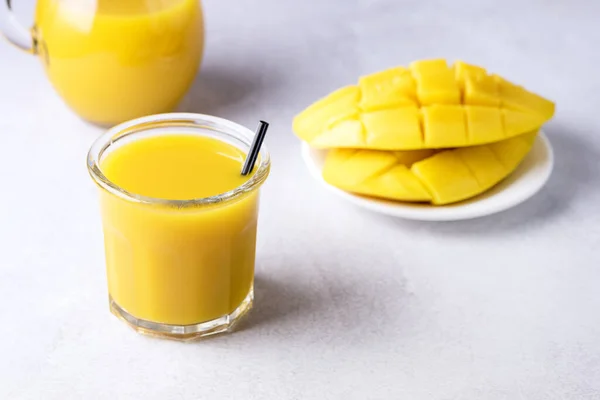 Glass of Tasty Ripe Mango Juice and Ripe Sliced Mango on Light Gray Background Vitamin and Healthy Drink Horizontal