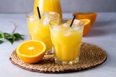 Açık gri arka planda siyah kamışlı Portakal Suyu Taze Portakal Vitamini veya Detox İçeceği