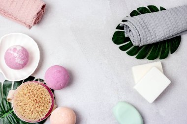 SPA Pembe Hayat Pembesi ve Açık Turuncu Banyo Bombaları Açık Gri Arkaplandaki Kozmetik Yağlar Yıkama Fırçası Gri ve Pembe Havlu Güzellik Konsepti