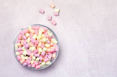 Gri Arkaplan Üst Görünümünde Renkli Minyatür Şekerlemeleri olan Cam Kase Boşluğu Kopyala