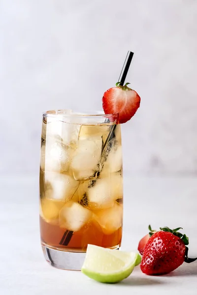 ライトグレーの背景に冷たい柑橘類とストロベリーアイスティーのガラスは 熟したライムとストロベリー健康的な梅酒で飾られています飲み物をリフレッシュ垂直 — ストック写真
