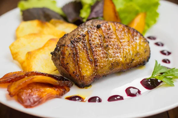 Peito de pato com batatas fritas, ervas, molho e maçãs caramelizadas. Mesa rústica de madeira. Vista superior. Close-up — Fotografia de Stock