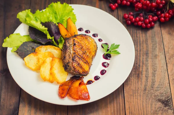 Peito de pato com batatas fritas, ervas, molho e maçãs caramelizadas. Mesa rústica de madeira. Vista superior. Close-up — Fotografia de Stock