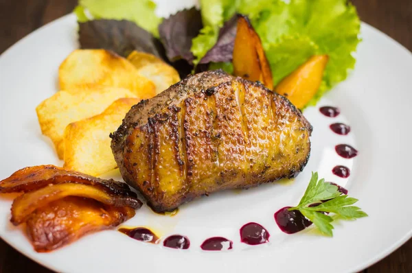 Entenbrust mit Kartoffelchips, Kräutern, Sauce und karamellisierten Äpfeln. Rustikaler Holztisch. Ansicht von oben. Nahaufnahme — Stockfoto