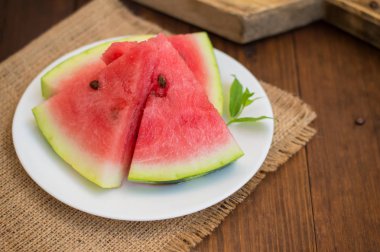 Karpuz dilimleri bir delikanlı ile nane ahşap zemin üzerine dilimlenmiş. Üstten Görünüm