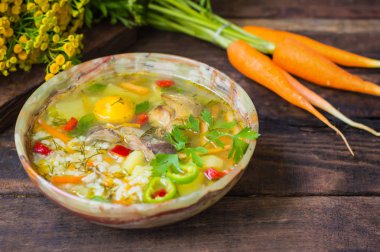 Tavuk kartonpiyerler ve yumurta sarısı ile pirinç çorbası. Ahşap rustik arka plan. Üstten Görünüm. Yakın çekim