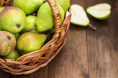 Olgun armut ahşap arka plan üzerinde bir sepet içinde. Üstten Görünüm. Yakın çekim