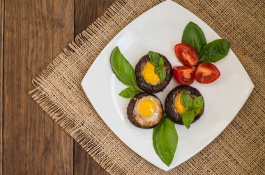 Champignon bıldırcın yumurtası fesleğen ve domates ile doldurulmuş. Ahşap arka plan. Yakın çekim