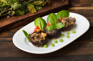 Champignon bıldırcın yumurtası fesleğen ve domates ile doldurulmuş. Ahşap arka plan. Yakın çekim