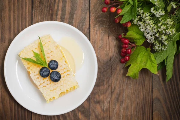 Favo con mirtilli e menta. Sfondo in legno. Vista dall'alto — Foto Stock