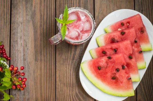 Jugo de sandía fresca sobre un fondo de rebanadas de mesa de madera. Primer plano — Foto de Stock